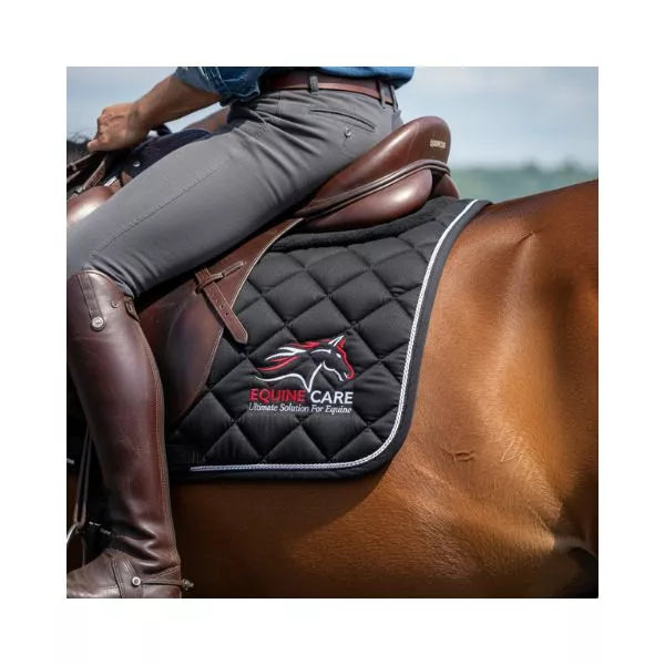 Close-up of Equine Care black quilted English saddle pad under English saddle showing secure non-slip fit