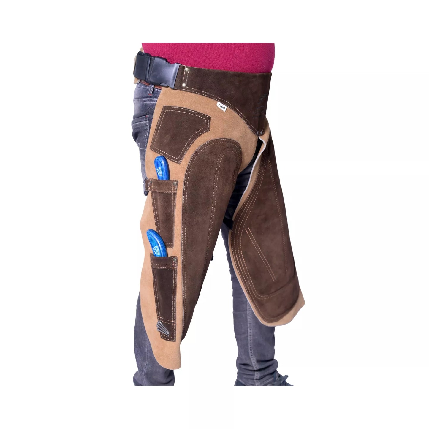 Premium beige suede leather farrier apron with EVA foam padding and canvas panels Side view of brown suede leather farrier chaps worn over jeans, featuring reinforced thigh protection and integrated tool pockets for professional horse shoeing and hoof care work