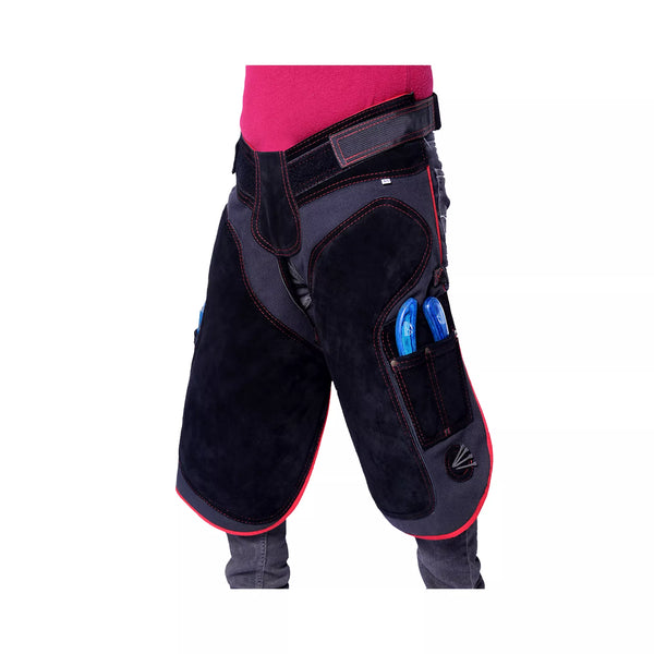 Equine Care Pro Artisan Farrier Apron Angled front view of black farrier chaps featuring red trim, reinforced thigh padding, adjustable waist belt, and dual side tool pockets for professional horse shoeing and hoof care work